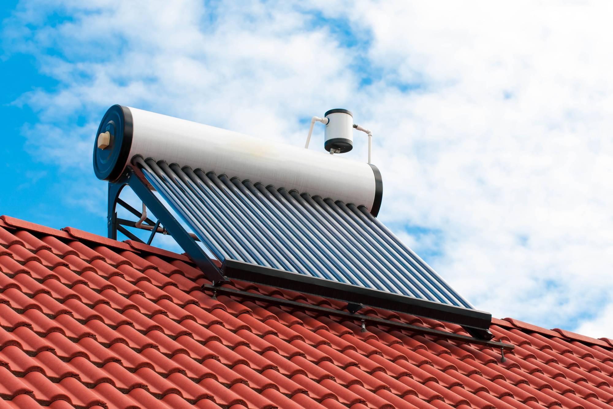 Solar water heater on roof top, beautiful blue sky background.